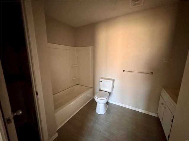 full bath with toilet, wood finished floors, baseboards, vanity, and shower / washtub combination