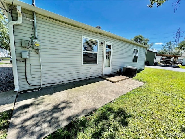 2209 Terminal Ave, Granite City, IL 62040 - back of house featuring central air condition unit, a lawn, and a patio area
