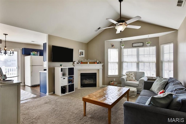 480 Benton Dr Unit J, Saint Peters, MO 63376 - carpeted living room featuring a ceiling fan, vaulted ceiling, a glass covered fireplace, and a chandelier