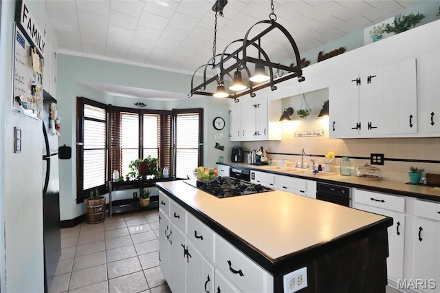 515 N Washington St, Mexico, MO 65265 - kitchen featuring black gas cooktop, a sink, a kitchen island, light tile patterned floors, and white cabinets