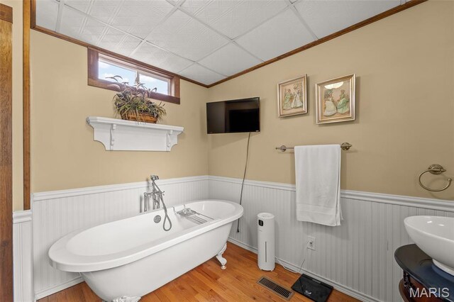 705 Jefferson St, Fulton, MO 65251 - bathroom with a wainscoted wall, a soaking tub, wood finished floors, and crown molding