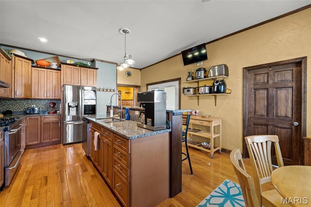 705 Jefferson St, Fulton, MO 65251 - kitchen featuring stainless steel appliances, a sink, ornamental molding, light wood-style floors, and a kitchen breakfast bar