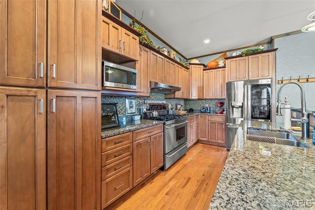 705 Jefferson St, Fulton, MO 65251 - kitchen featuring appliances with stainless steel finishes, a sink, under cabinet range hood, and light stone countertops