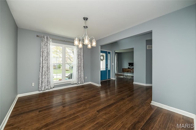 unfurnished dining area with a chandelier, wood finished floors, and baseboards