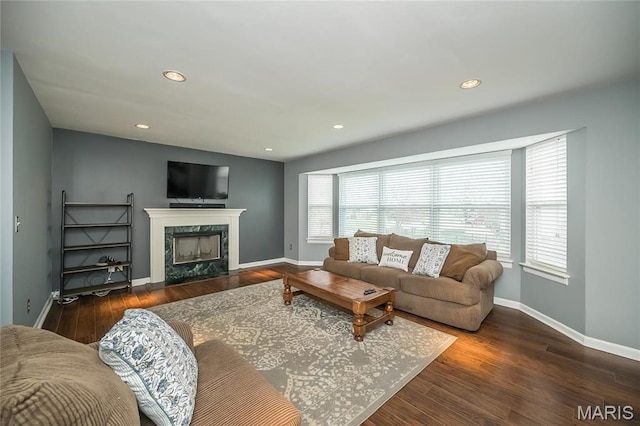 living room featuring wood finished floors, a high end fireplace, baseboards, and recessed lighting