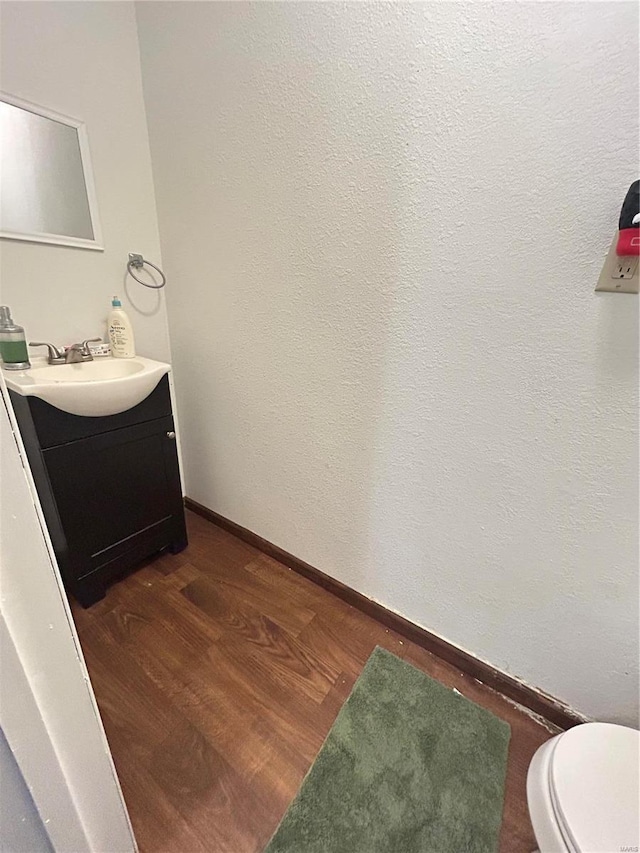 16892 Beaufort Rd, Crocker, MO 65452 - half bathroom featuring vanity, wood finished floors, baseboards, and toilet