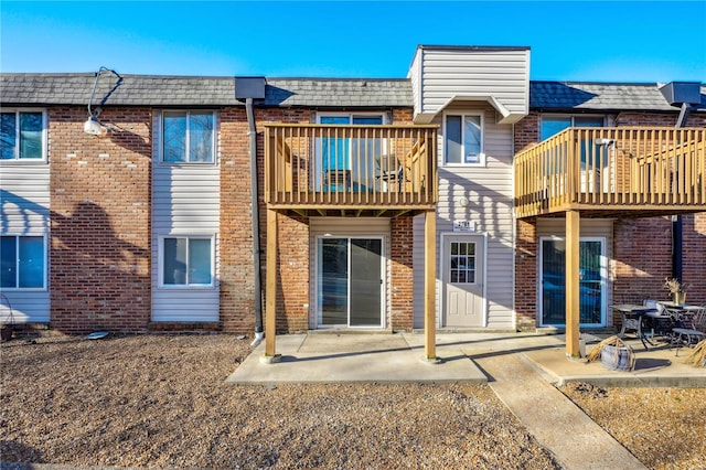 2781 Blackforest Dr Unit B, Saint Louis, MO 63129 - back of house featuring a balcony, brick siding, and mansard roof