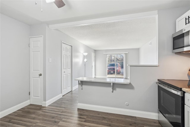 2781 Blackforest Dr Unit B, Saint Louis, MO 63129 - kitchen featuring appliances with stainless steel finishes, a kitchen breakfast bar, dark wood-style floors, white cabinetry, and a ceiling fan