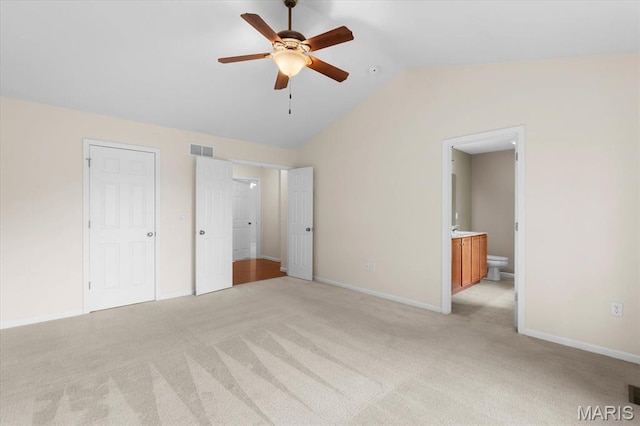 724 E Wesley Dr, Ofallon, IL 62269 - unfurnished bedroom featuring lofted ceiling, light carpet, ensuite bath, and baseboards