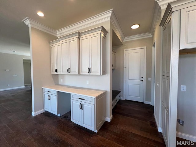 kitchen featuring dark wood finished floors, light countertops, ornamental molding, baseboards, and recessed lighting