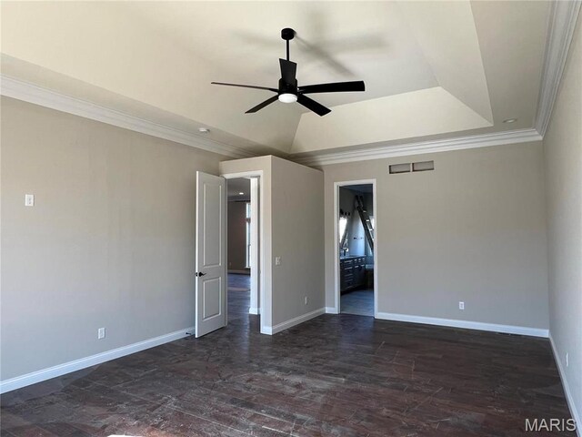 unfurnished room featuring ceiling fan, baseboards, ornamental molding, a raised ceiling, and dark wood-type flooring