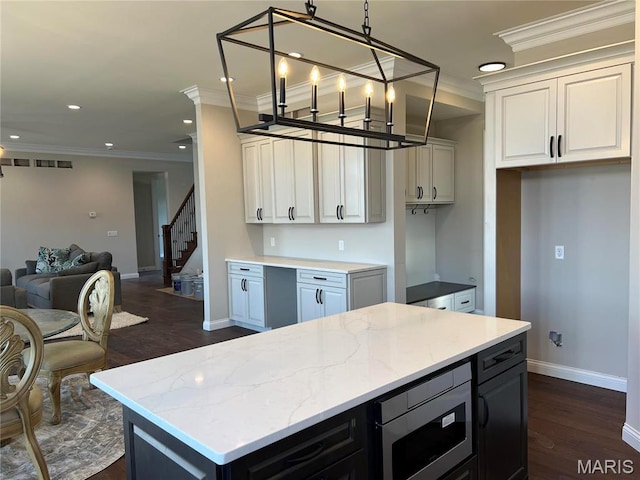 kitchen with crown molding, baseboards, dark wood-type flooring, a center island, and open floor plan