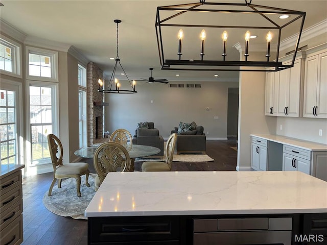 kitchen with crown molding, open floor plan, baseboards, dark wood-type flooring, and a chandelier