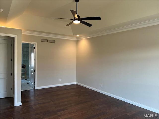 empty room with a ceiling fan, baseboards, ornamental molding, dark wood-style floors, and vaulted ceiling
