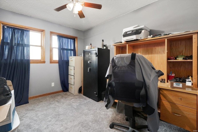 office area with ceiling fan, a textured ceiling, light carpet, and baseboards