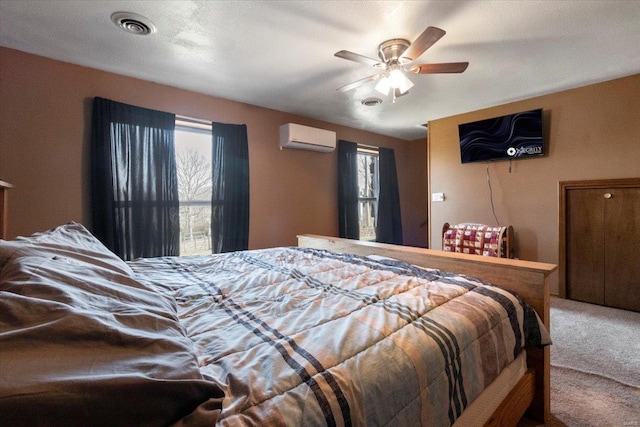 bedroom with an AC wall unit, carpet flooring, and ceiling fan