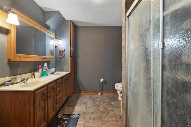 bathroom with a shower stall, toilet, baseboards, and double vanity