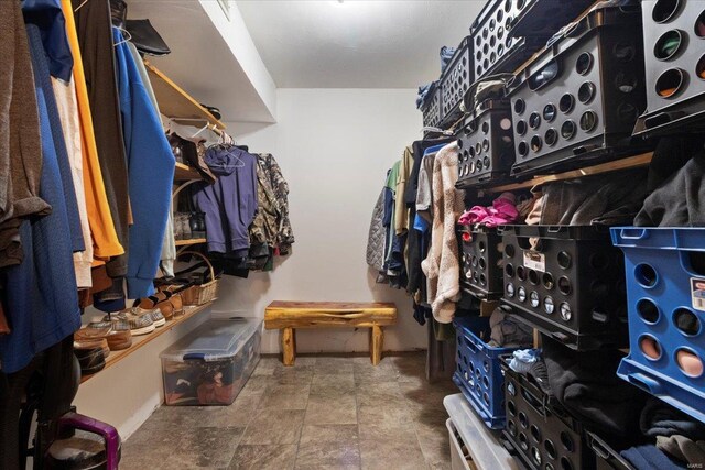 spacious closet featuring stone finish flooring