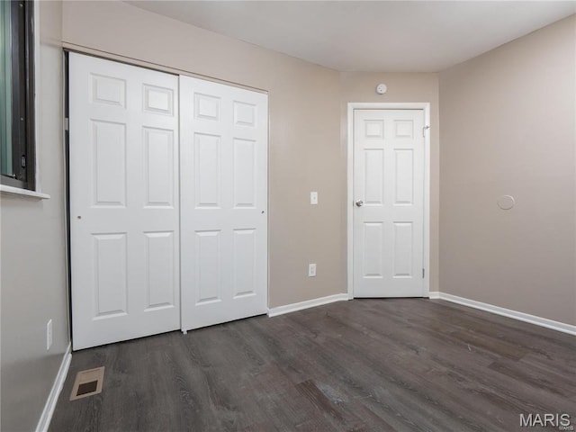 1464 Monopoly Dr, Florissant, MO 63031 - unfurnished bedroom featuring dark wood-style floors, baseboards, and a closet