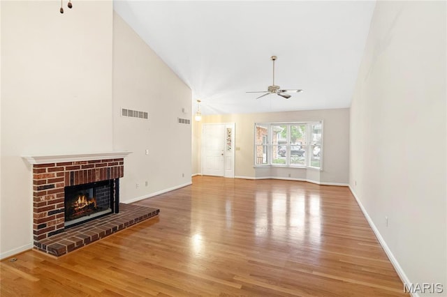 7310 Westover Colonial Ln, Saint Louis, MO 63119 - unfurnished living room featuring a ceiling fan, wood finished floors, a brick fireplace, baseboards, and high vaulted ceiling