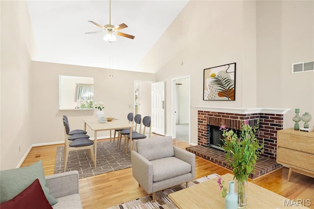 7310 Westover Colonial Ln, Saint Louis, MO 63119 - living room featuring ceiling fan, wood finished floors, high vaulted ceiling, a brick fireplace, and baseboards