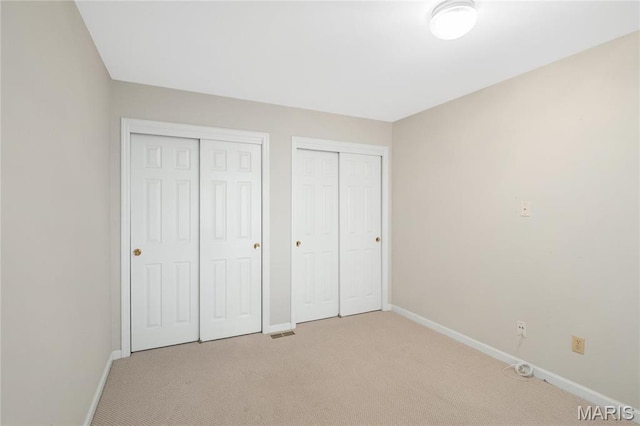 7310 Westover Colonial Ln, Saint Louis, MO 63119 - unfurnished bedroom featuring multiple closets, baseboards, and light colored carpet