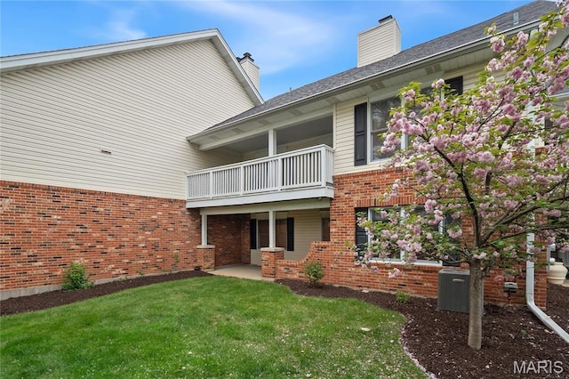 7310 Westover Colonial Ln, Saint Louis, MO 63119 - back of property featuring a balcony, brick siding, a yard, a chimney, and central AC