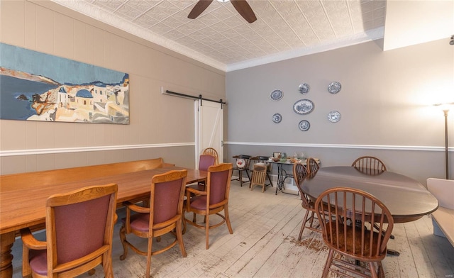 305 S Alvarado Ave, Belle, MO 65013 - dining room with wood-type flooring, a barn door, crown molding, a ceiling fan, and an ornate ceiling