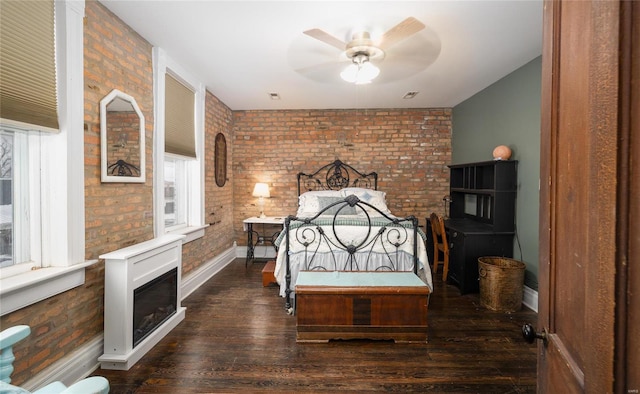 305 S Alvarado Ave, Belle, MO 65013 - bedroom with a fireplace, baseboards, brick wall, and dark wood finished floors