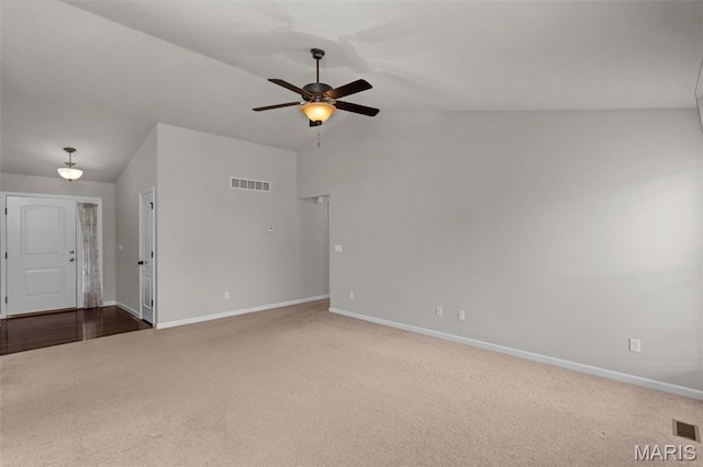 carpeted empty room with lofted ceiling, baseboards, and a ceiling fan