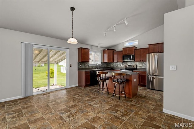 kitchen featuring appliances with stainless steel finishes, dark countertops, backsplash, baseboards, and lofted ceiling