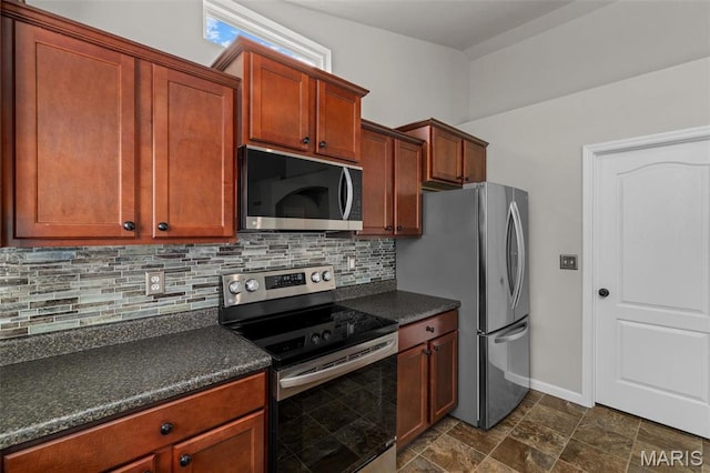 kitchen with stainless steel appliances, dark countertops, backsplash, and baseboards