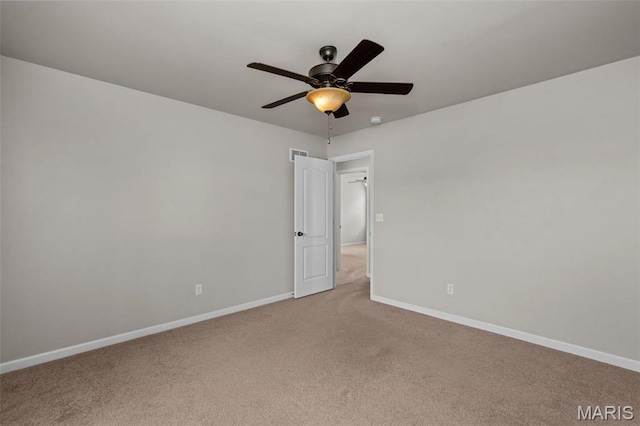 empty room featuring light colored carpet, baseboards, and ceiling fan