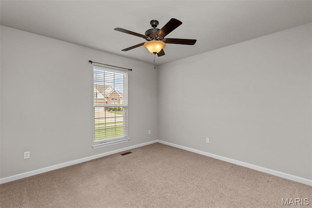 carpeted empty room featuring baseboards and ceiling fan