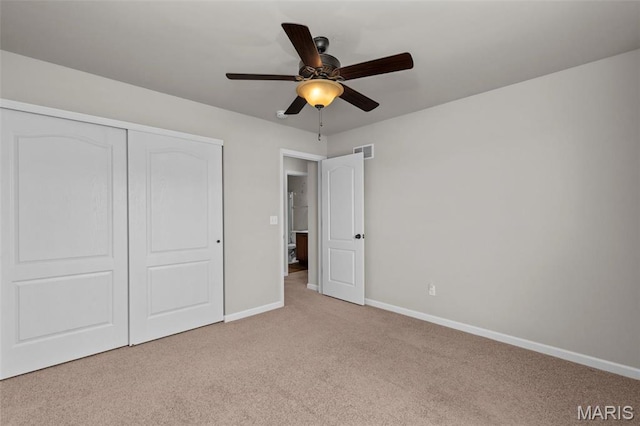unfurnished bedroom featuring light carpet, baseboards, a closet, and ceiling fan
