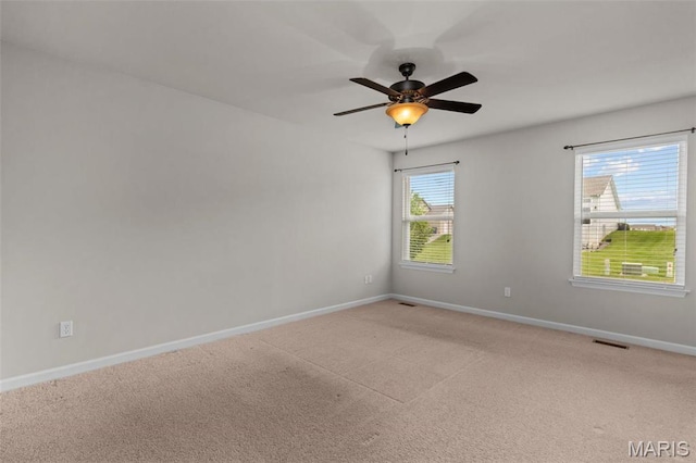 unfurnished room featuring baseboards, light carpet, and ceiling fan