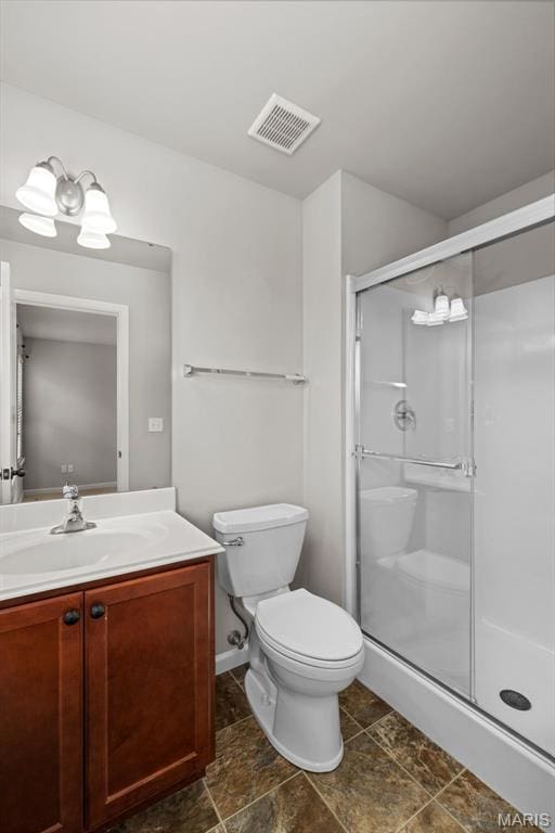 full bath with toilet, a stall shower, vanity, and baseboards