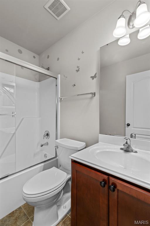 full bath featuring vanity, toilet, and bath / shower combo with glass door