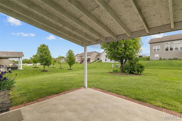 view of grassy yard featuring a patio area and a residential view
