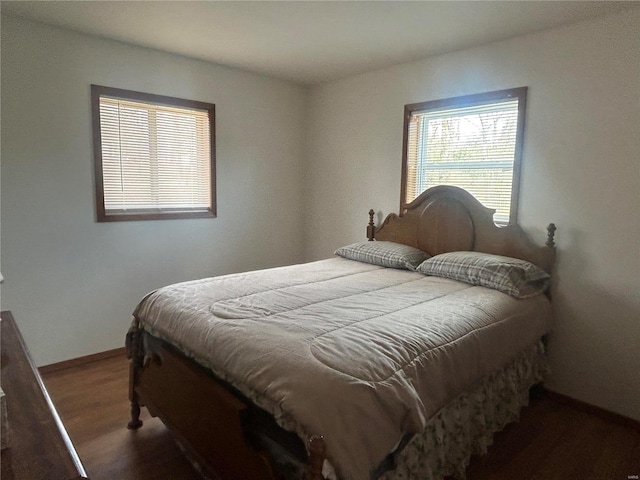 bedroom with wood finished floors and baseboards