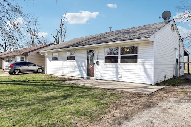view of front of house featuring a front yard and a shingled roof