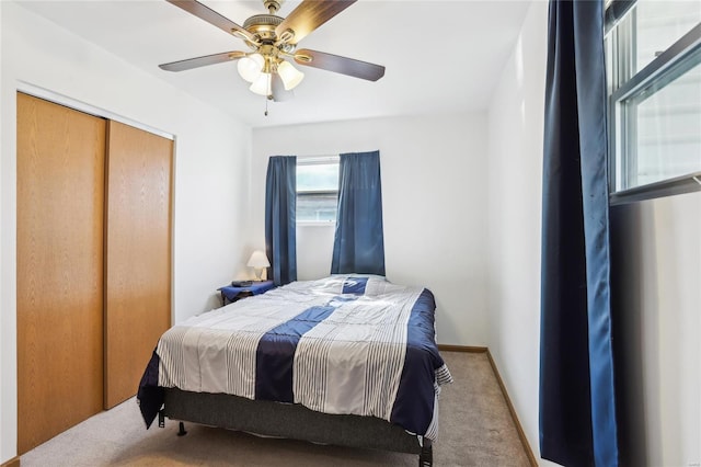 carpeted bedroom featuring a closet, ceiling fan, and baseboards