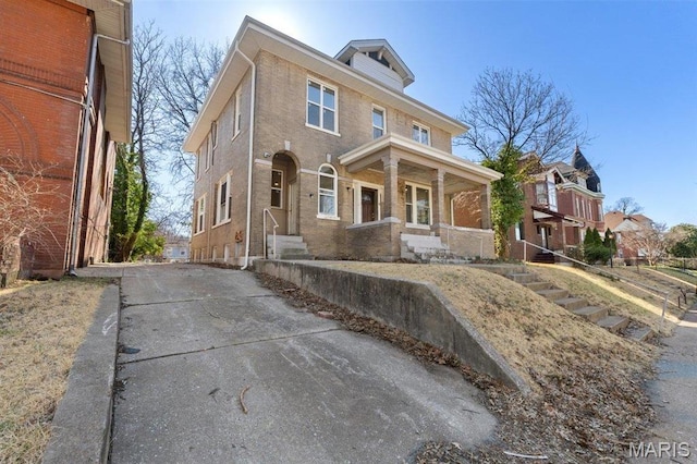 4 Lewis Pl, Saint Louis, MO 63113 - traditional style home featuring driveway, a porch, and brick siding