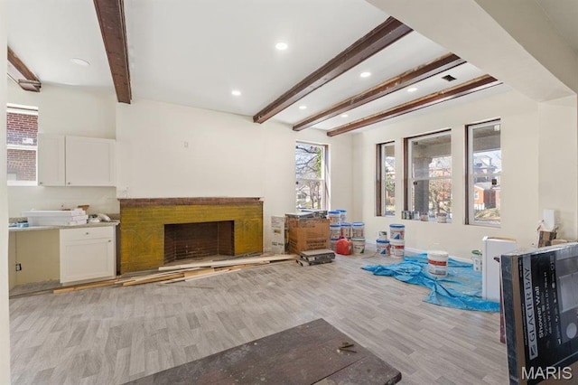 4 Lewis Pl, Saint Louis, MO 63113 - unfurnished living room with light wood-type flooring, beam ceiling, recessed lighting, a fireplace with raised hearth, and baseboards