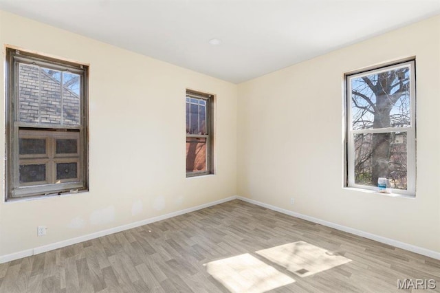 4 Lewis Pl, Saint Louis, MO 63113 - unfurnished room featuring wood finished floors, healthy amount of natural light, and baseboards