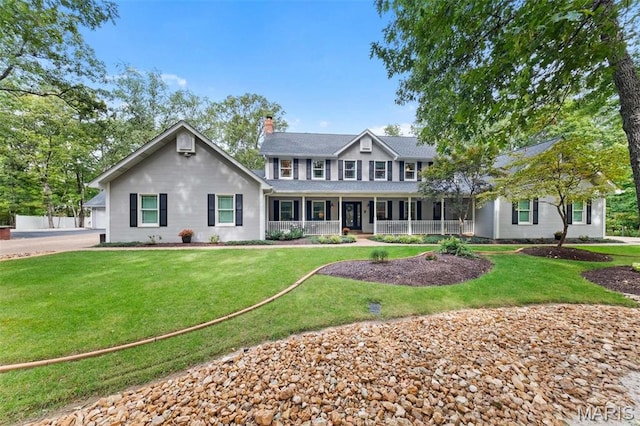 colonial inspired home featuring a porch, a chimney, and a front lawn