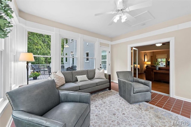 tiled living area featuring ceiling fan and baseboards