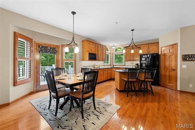 dining space featuring light wood-style floors and baseboards