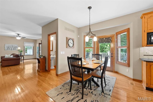 dining space with light wood-type flooring, baseboards, and a ceiling fan