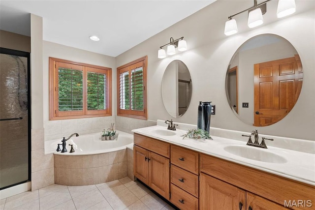 bathroom with a bath, tile patterned flooring, double vanity, and a shower with shower door